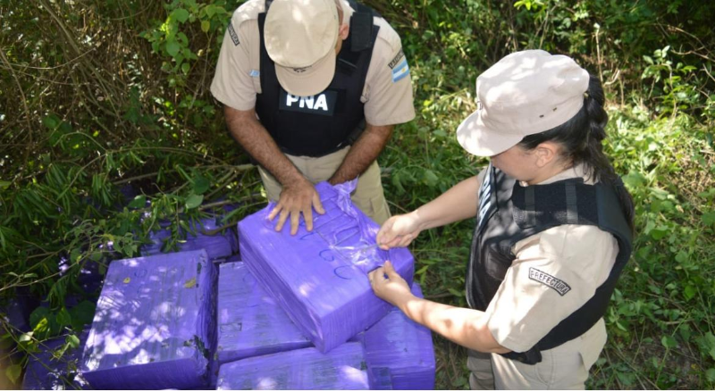 Dos agentes revisando los bultos hallados. 