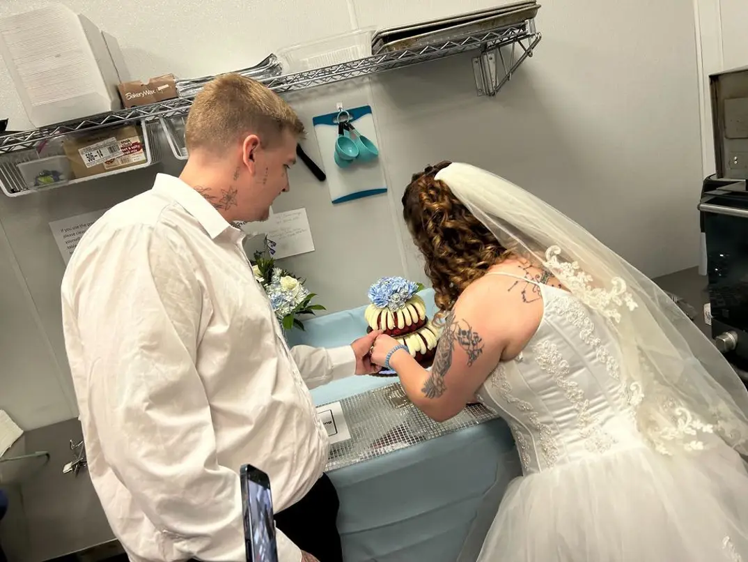 El matrimonio cortando el pastel de bodas en la cocina del local de HOP donde Tiana trabaja (Foto: TMZ).