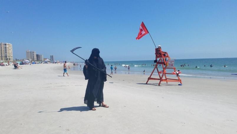 El hombre camina disfrazado por las playas de Florida para alertar sobre el coronavirus (Twitter).