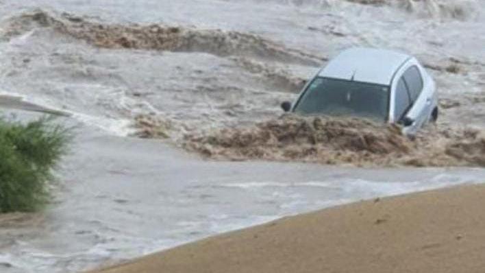 Un auto fue arrastrado por el agua hasta la playa.