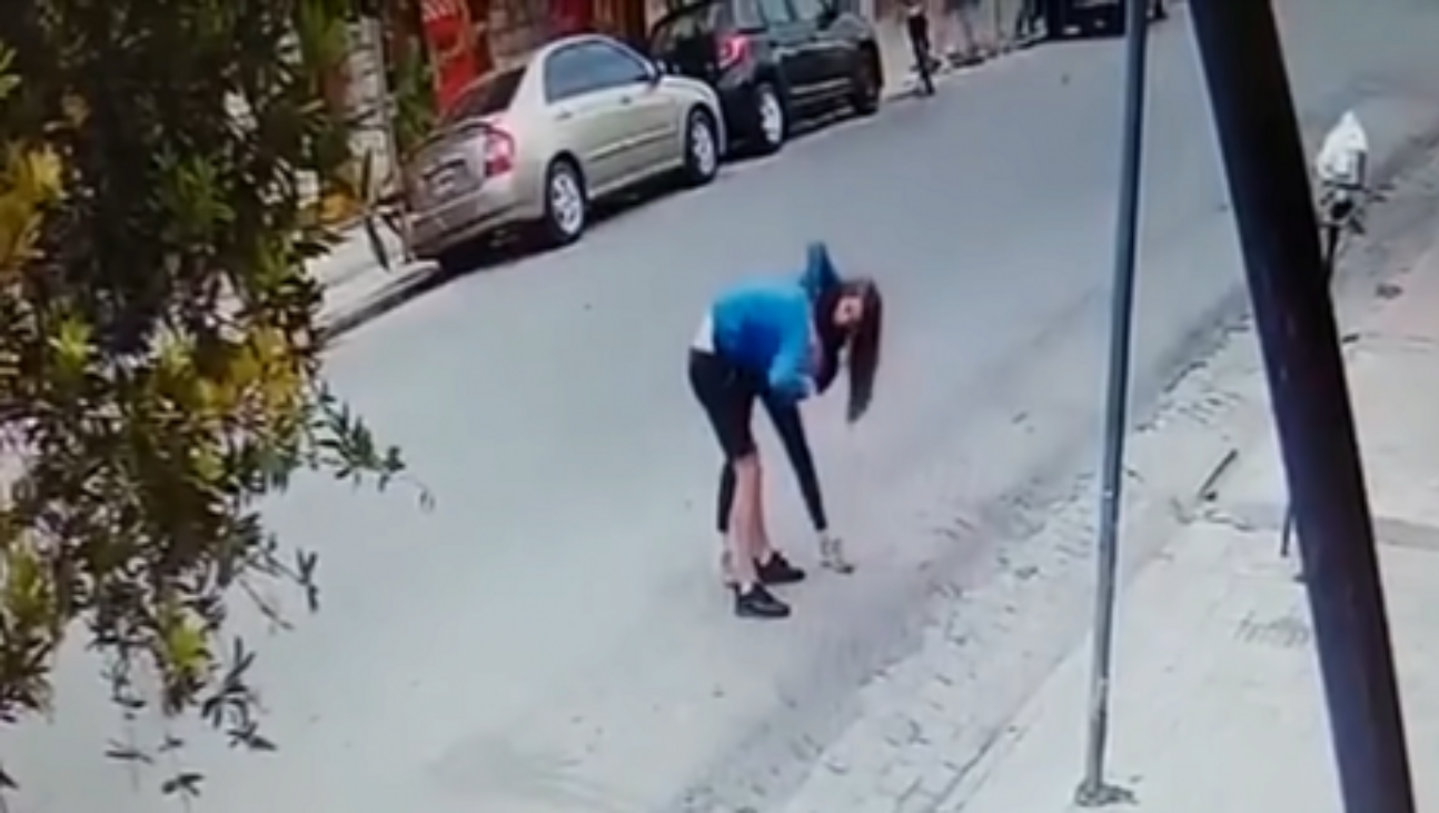 El momento en que los novios forcejean en una calle de Cosquín.