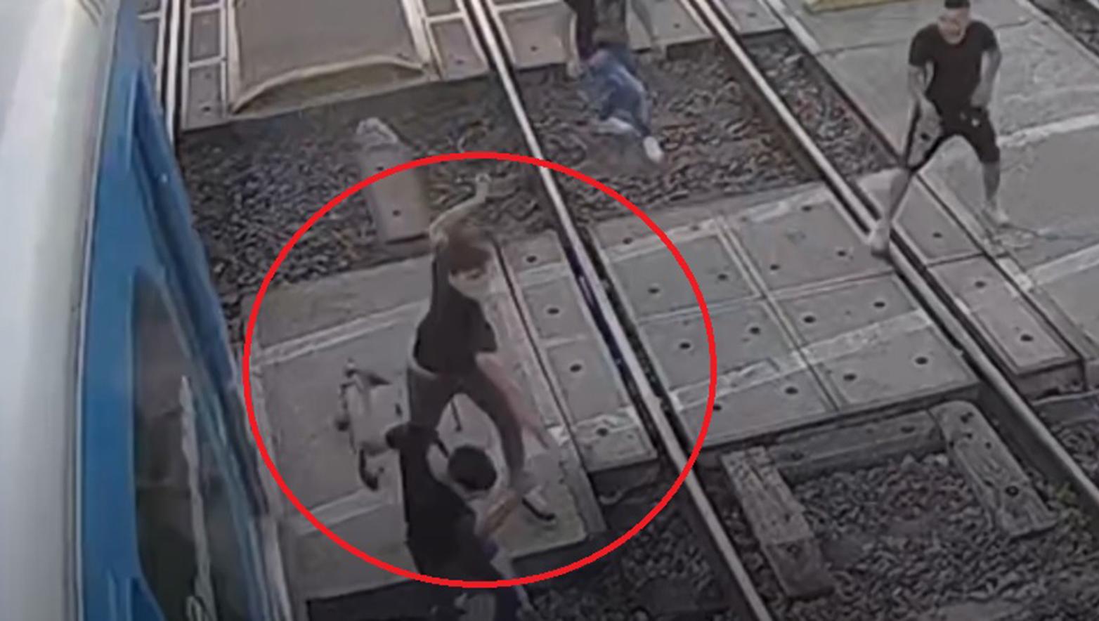 Dos adolescentes a los golpes, mientras el tren les pasa a unos centímetros (Captura de video).