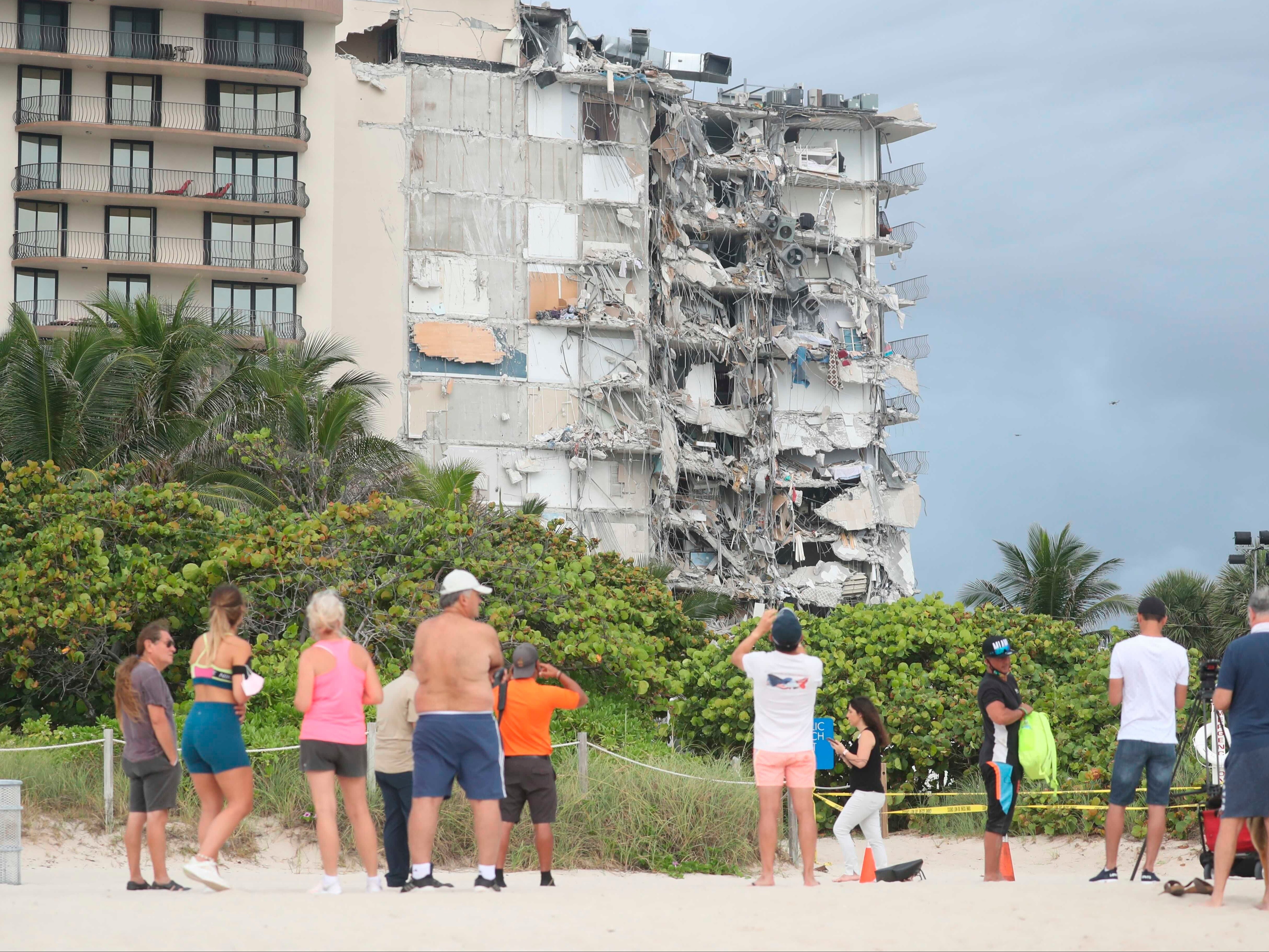 El derrumbe puede verse desde la playa, donde residentes de la zona se reunieron tras la tragedia.