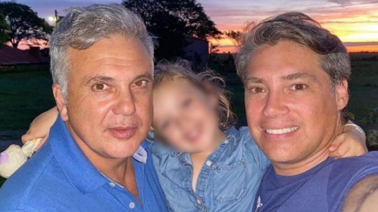 Fabián Nuñez y Andrés Galfrascoli, abrazados por su hija Sofía.