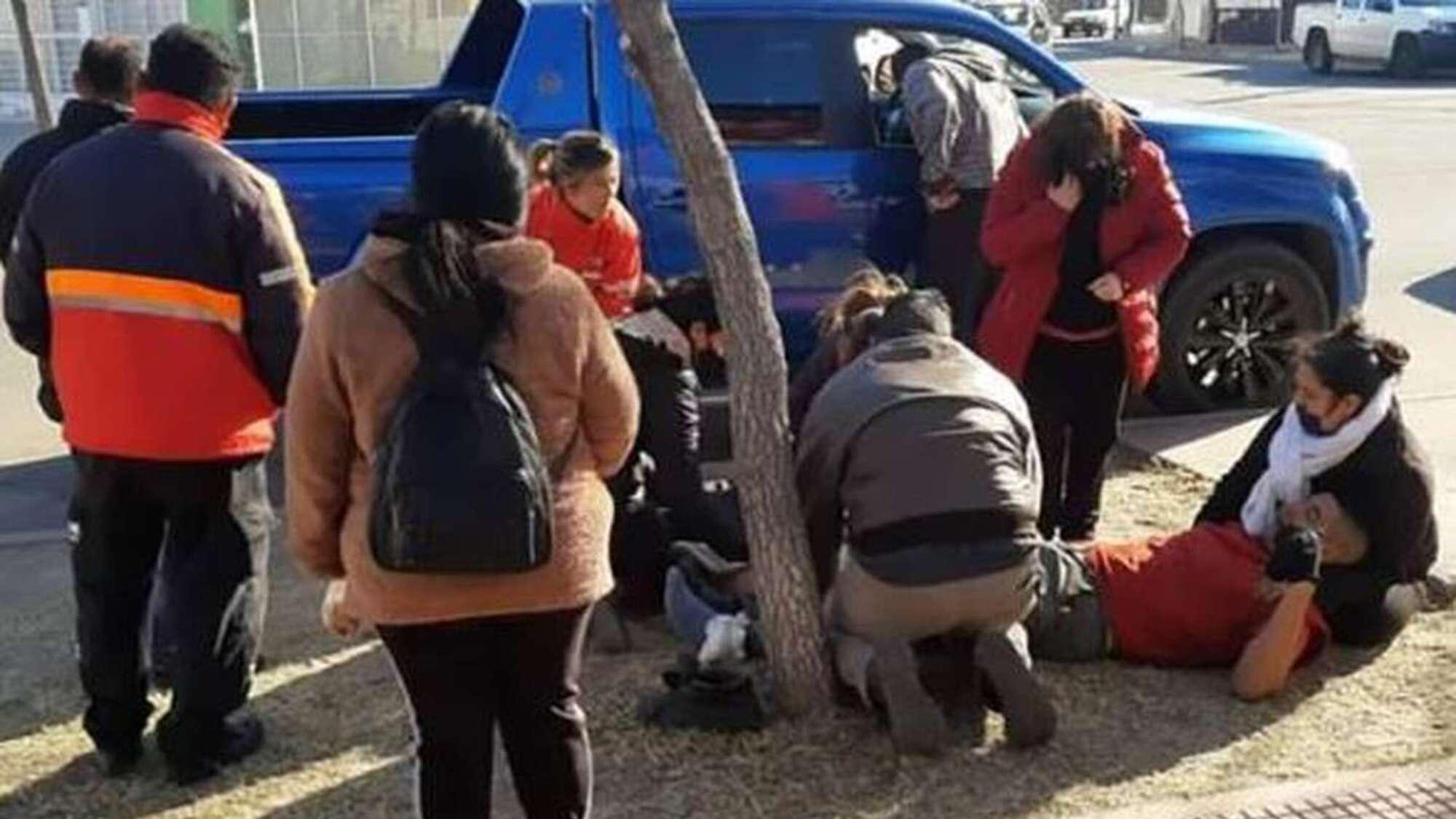 La empresaria y su chofer, en el piso, poco después de haber sido baleados en el asalto.