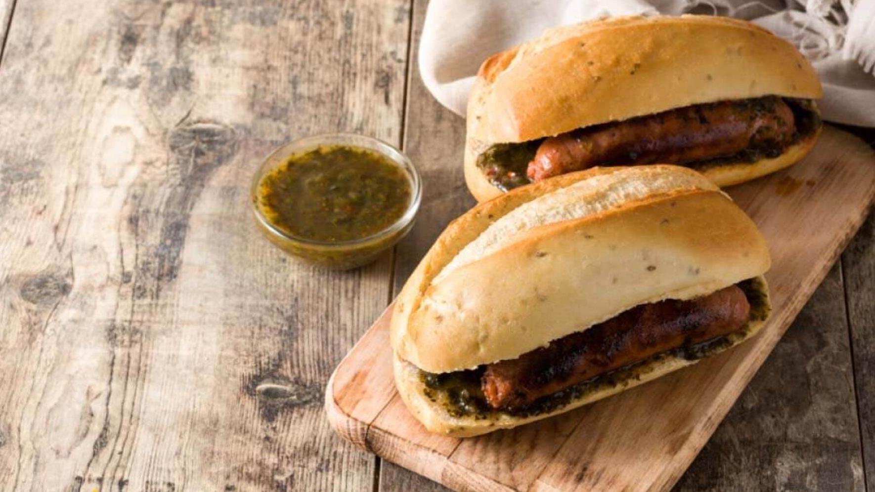 El choripán argentino puede acompañarse con salsa criolla o chimichurri.  