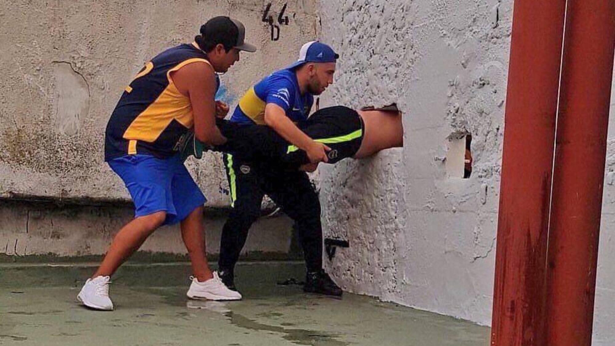 Hinchas intenta ingresar al estadio a través de un pequeño agujero en la pared.