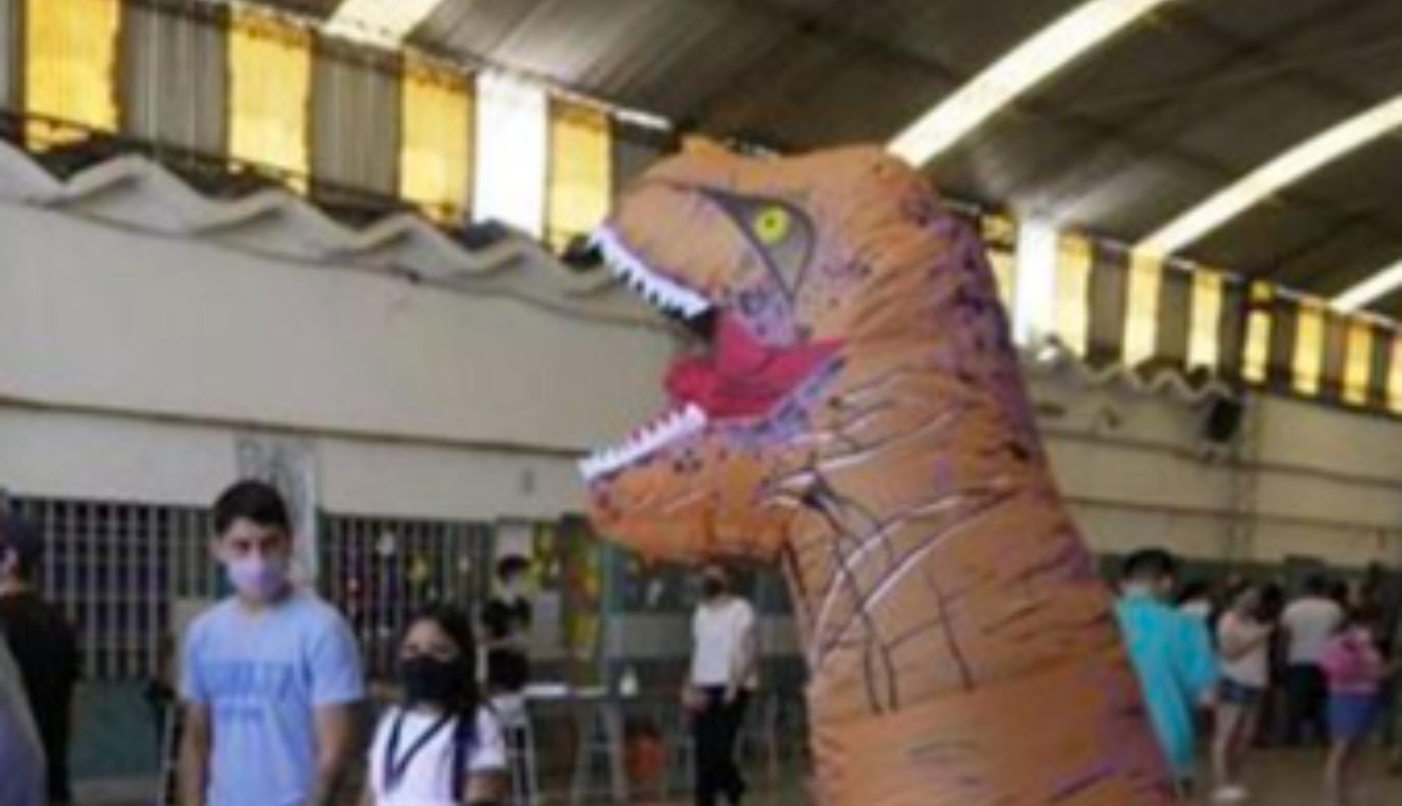 El hombre disfrazado de dinosaurio, la gran atracción en una escuela de Rosario durante las elecciones.