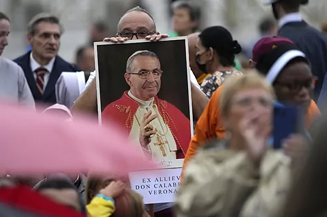 Un hombre sostiene un retrato de Juan Pablo I en la beatificación.