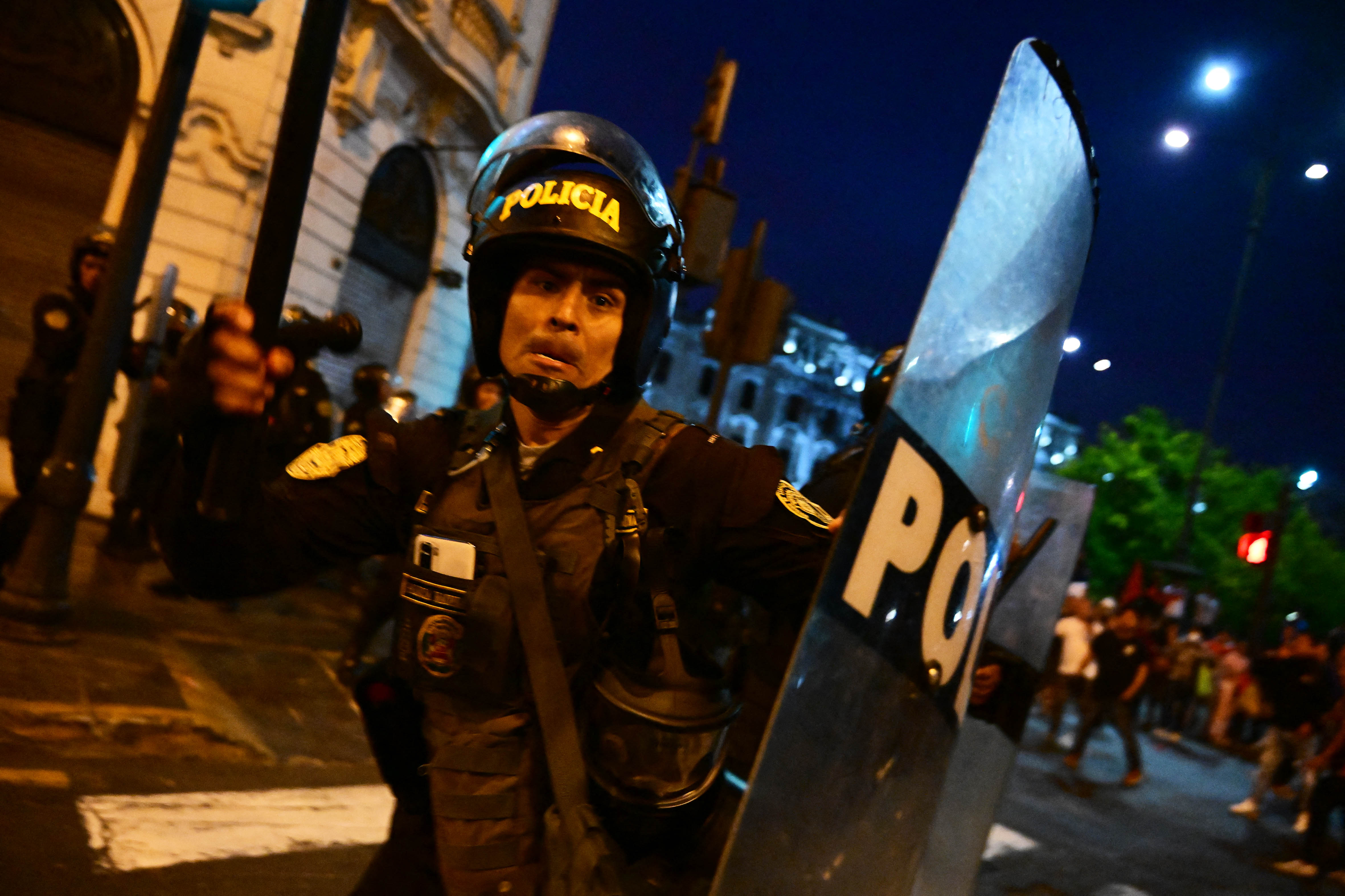 Riot police clash with supporters of former President Pedro Castillo during a protest to demand the closure of Congress and the release of Castillo in downtown Lima, on December 15, 2022. - Crowds of supporters of Peru's ex-president Pedro Castillo converged on congress Thursday despite a state of emergency declared in an effort to halt sometimes deadly protests triggered by his ouster last week. (Photo by MARTIN BERNETTI / AFP)