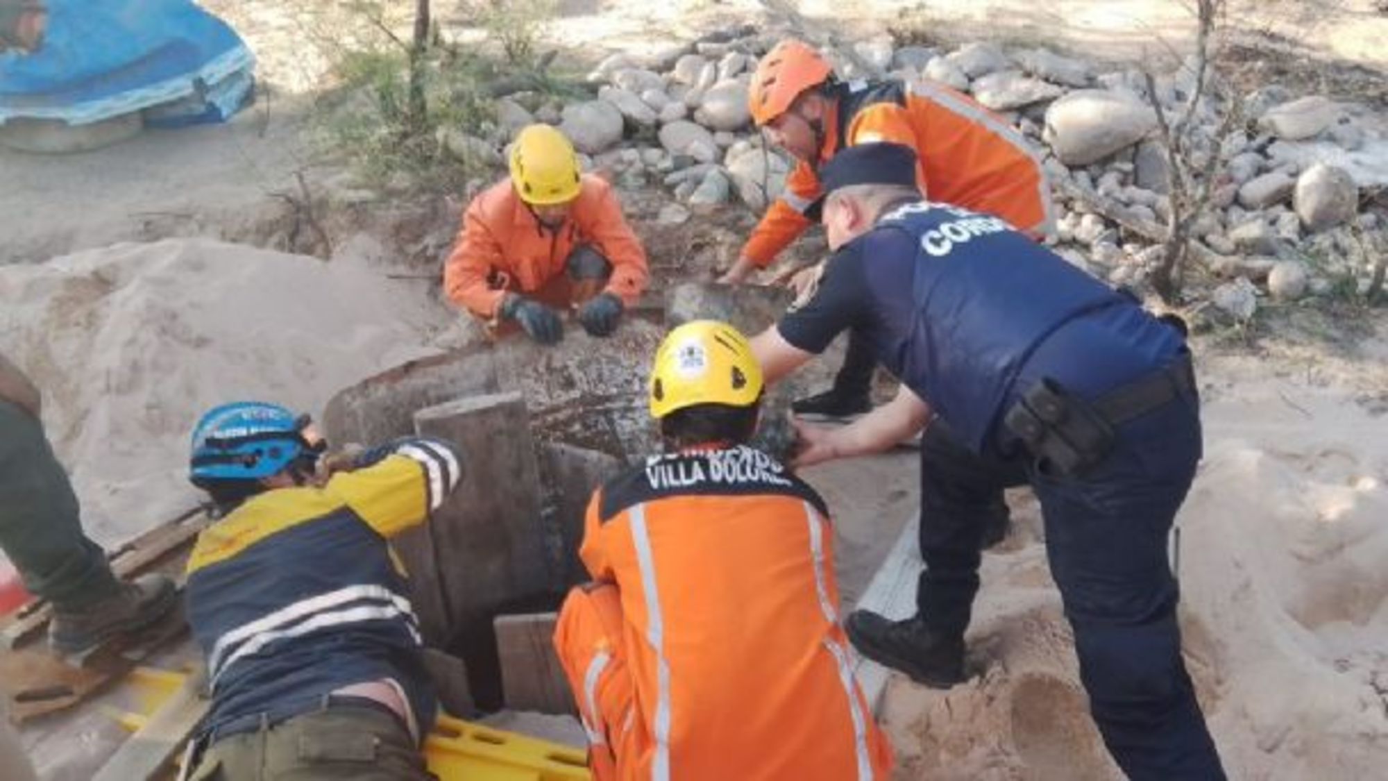 Policías y bomberos trabajando en el rescate de la mujer.