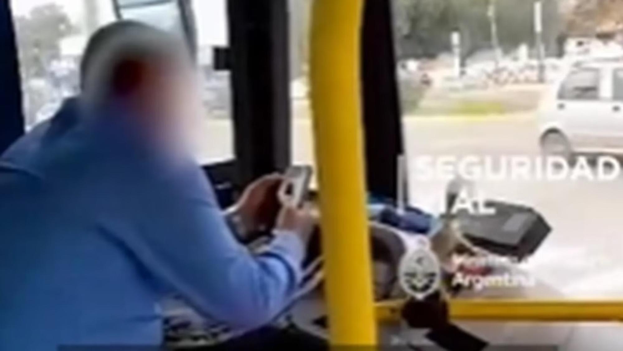 Manejaba un colectivo sin usar cinturón de seguridad y viendo el celular (Captura de video).